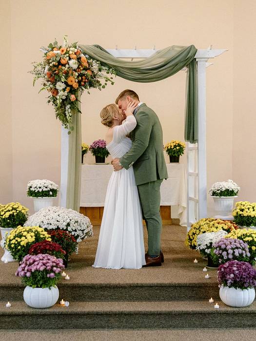 Bride and groom kissing at the alter
