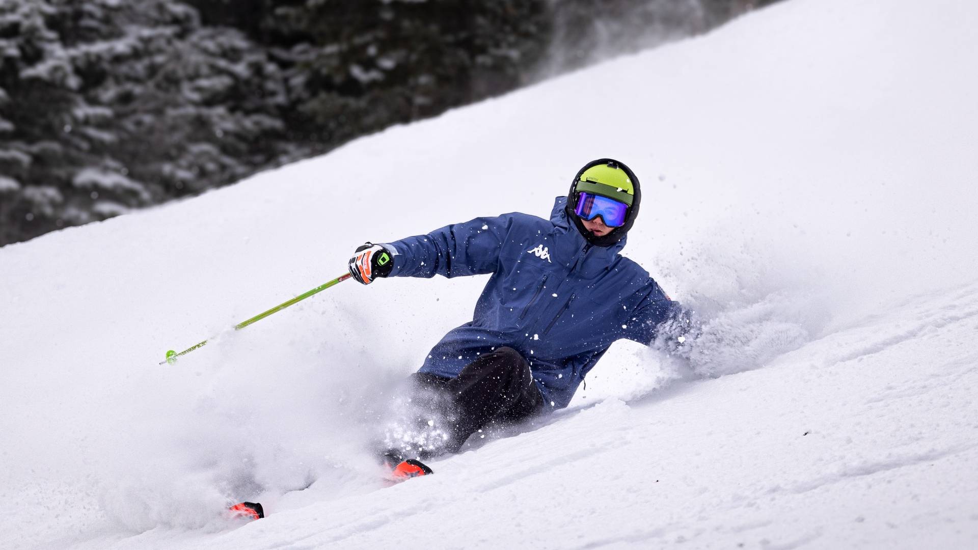 Skier carving a turn on steep slope