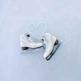 Figure skates on ice with laces shaped as a heart