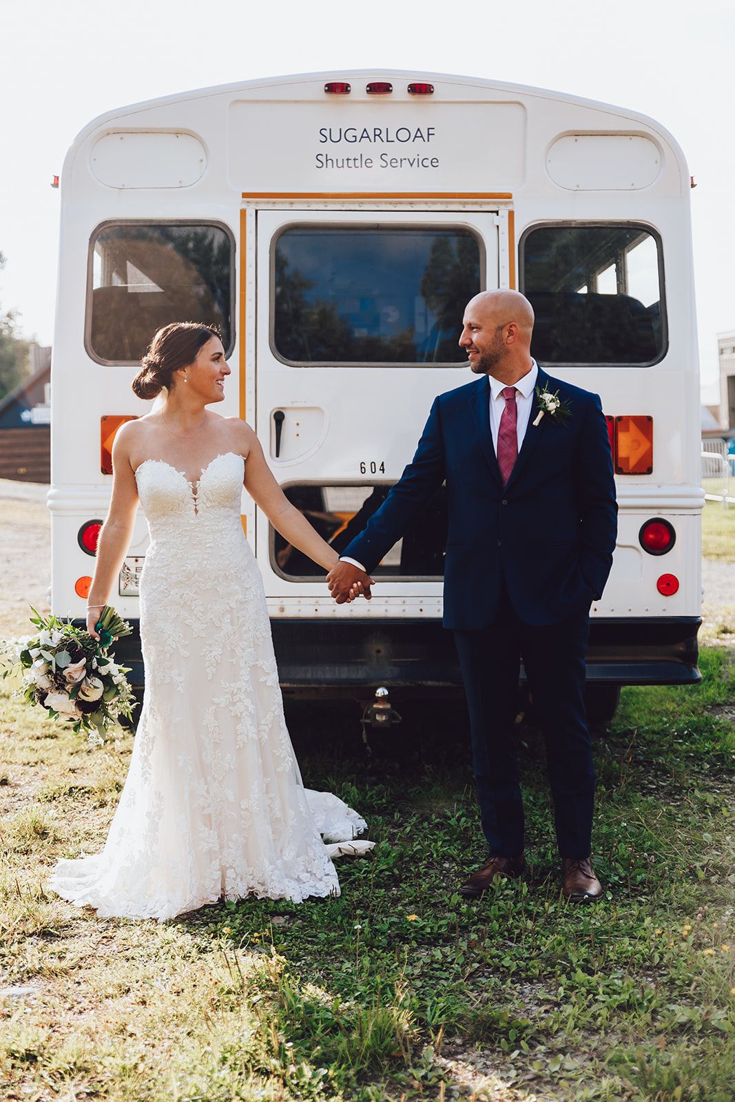 Bride and groom in front of shuttle bus