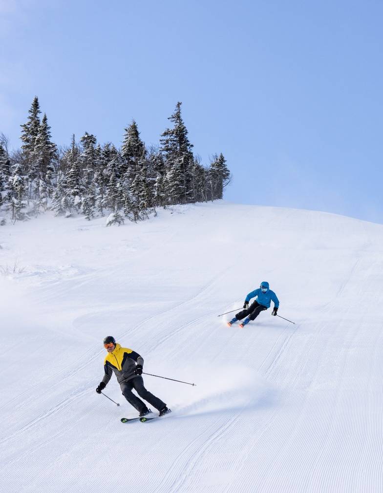 Three skiers on Sluice headwall in succession