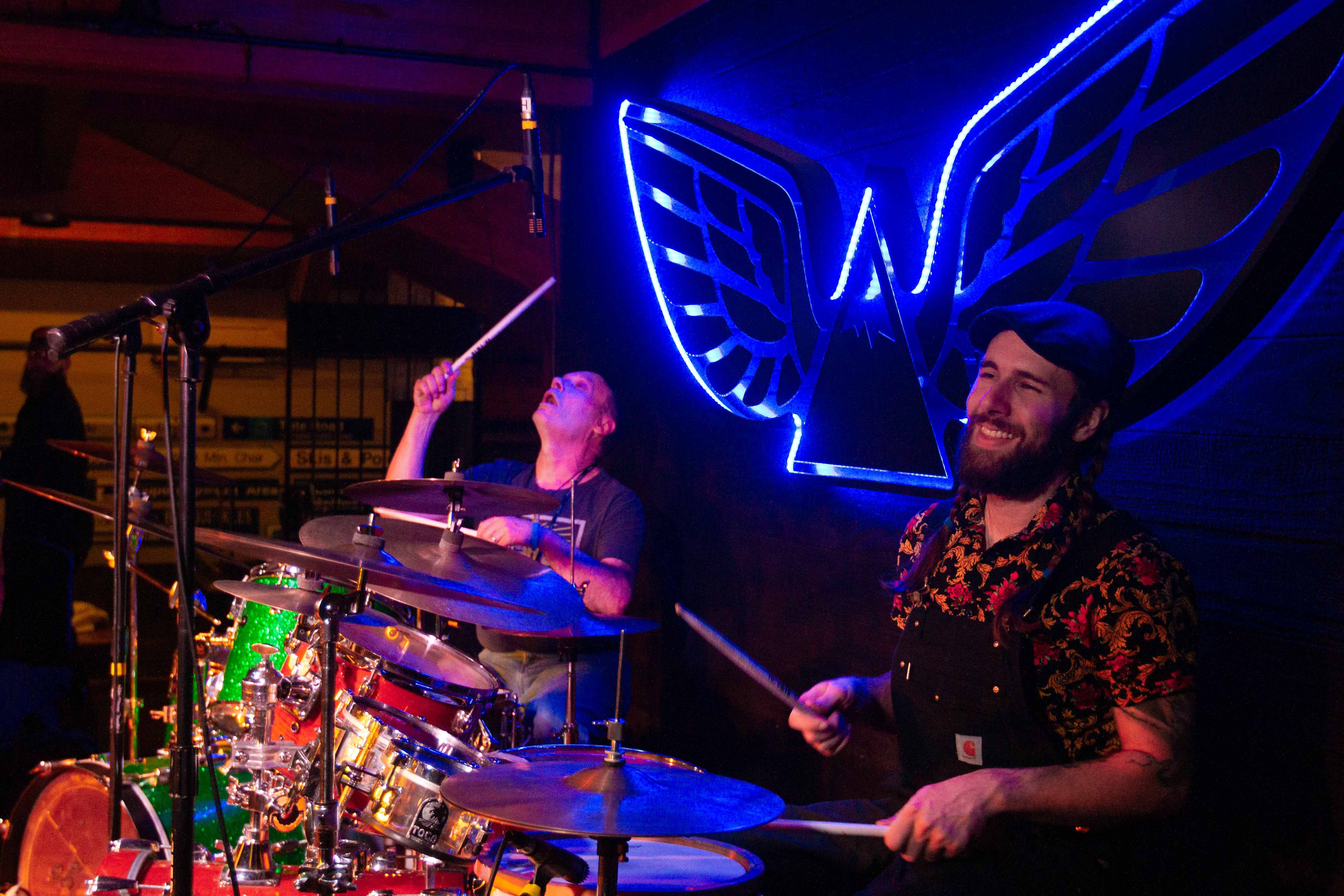Band drumming and smiling on stage