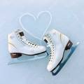 Figure skates on ice with laces shaped as a heart