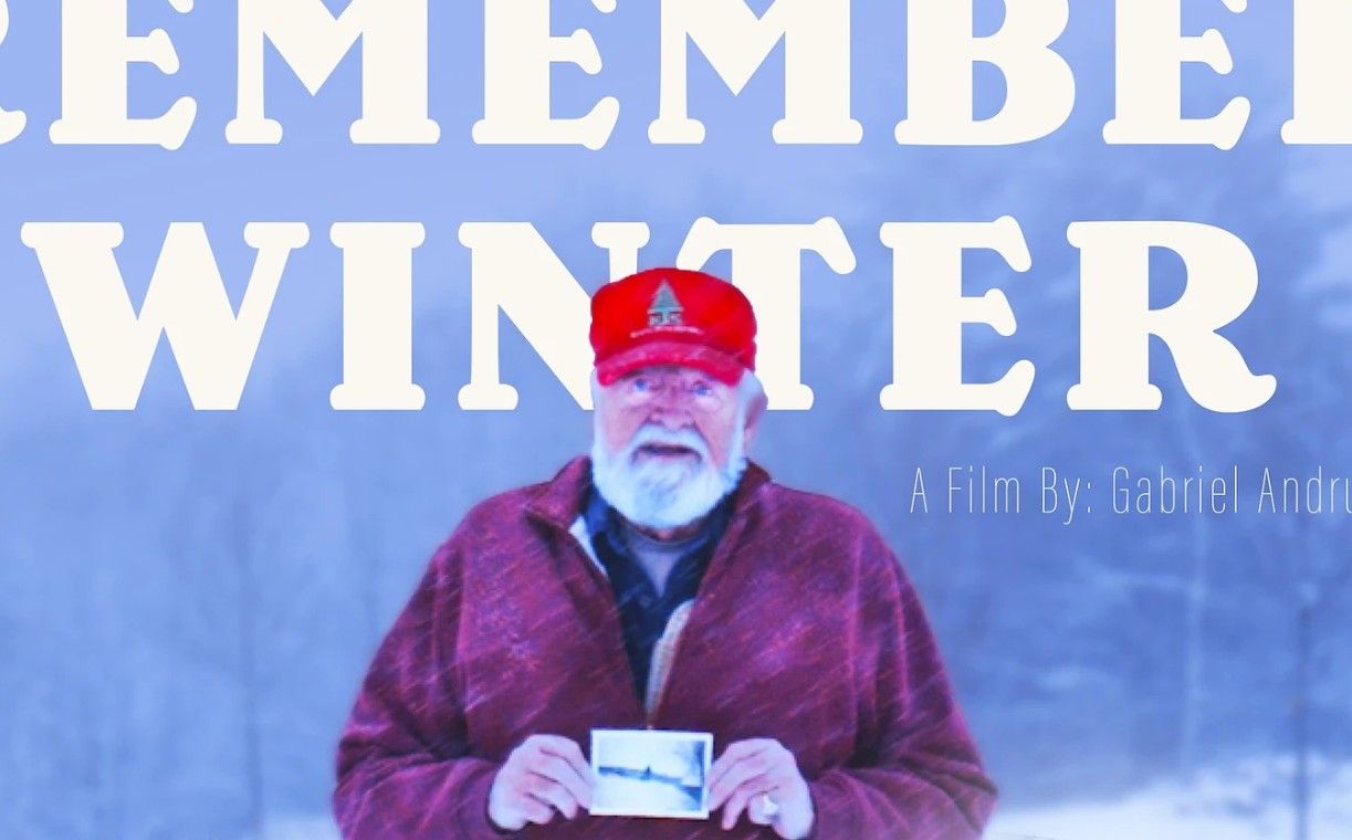 Screenshot of a man holding a photo