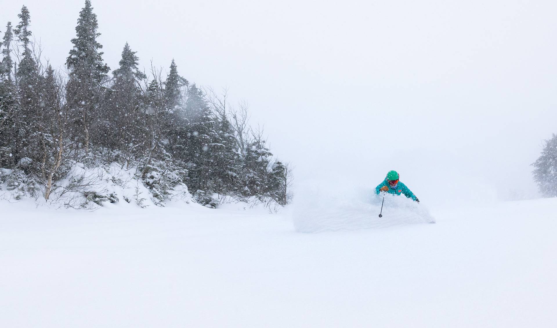 A snowboarder rips through fresh powder