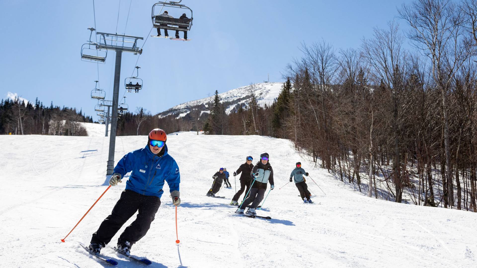 Ski instructor skiing with students