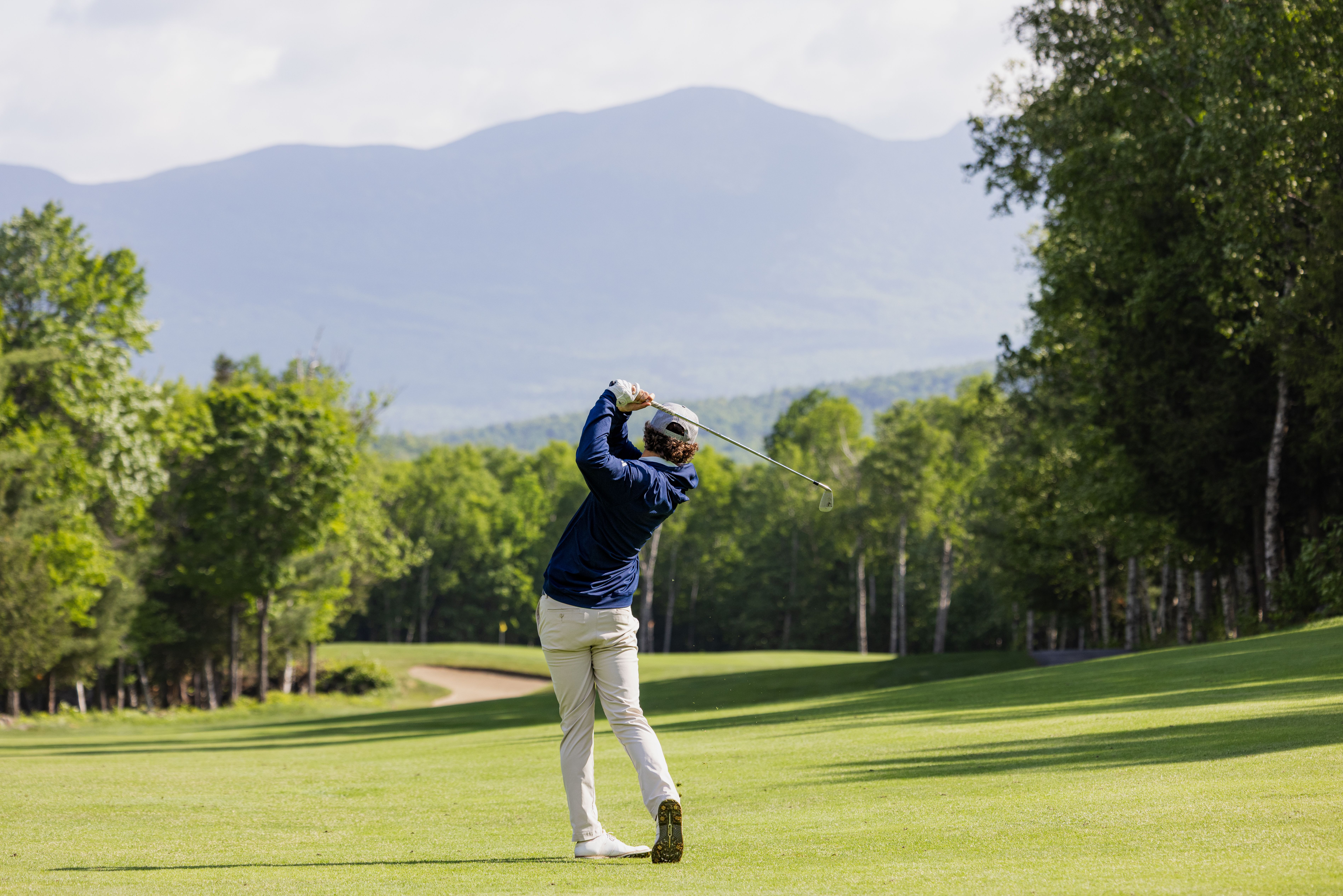 Golfer swinging on course