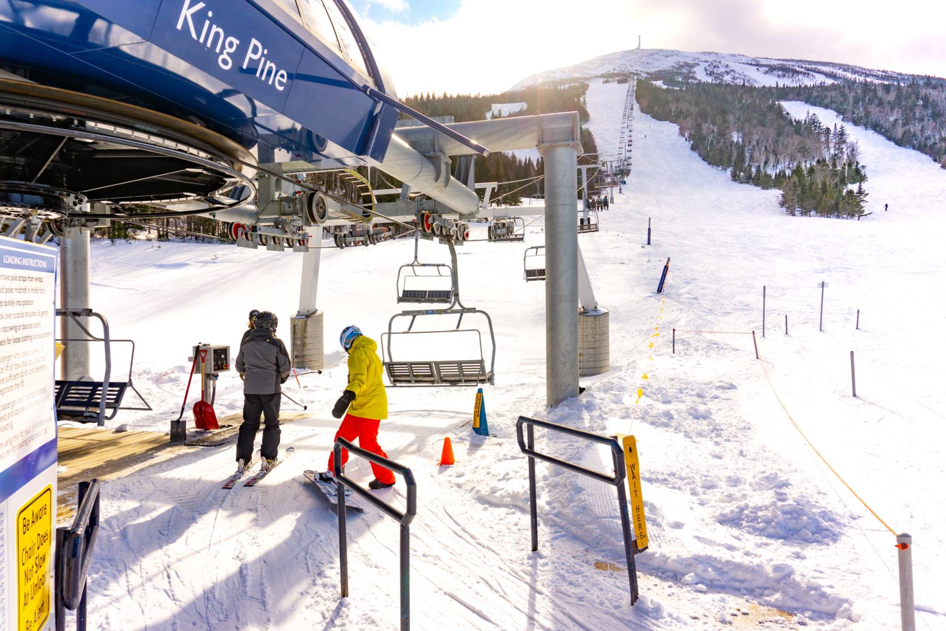 Skier and rider entering lift