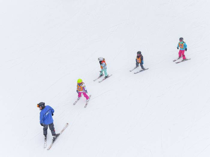 Children on Skis following Instructor
