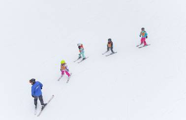 young skiers following an instructor