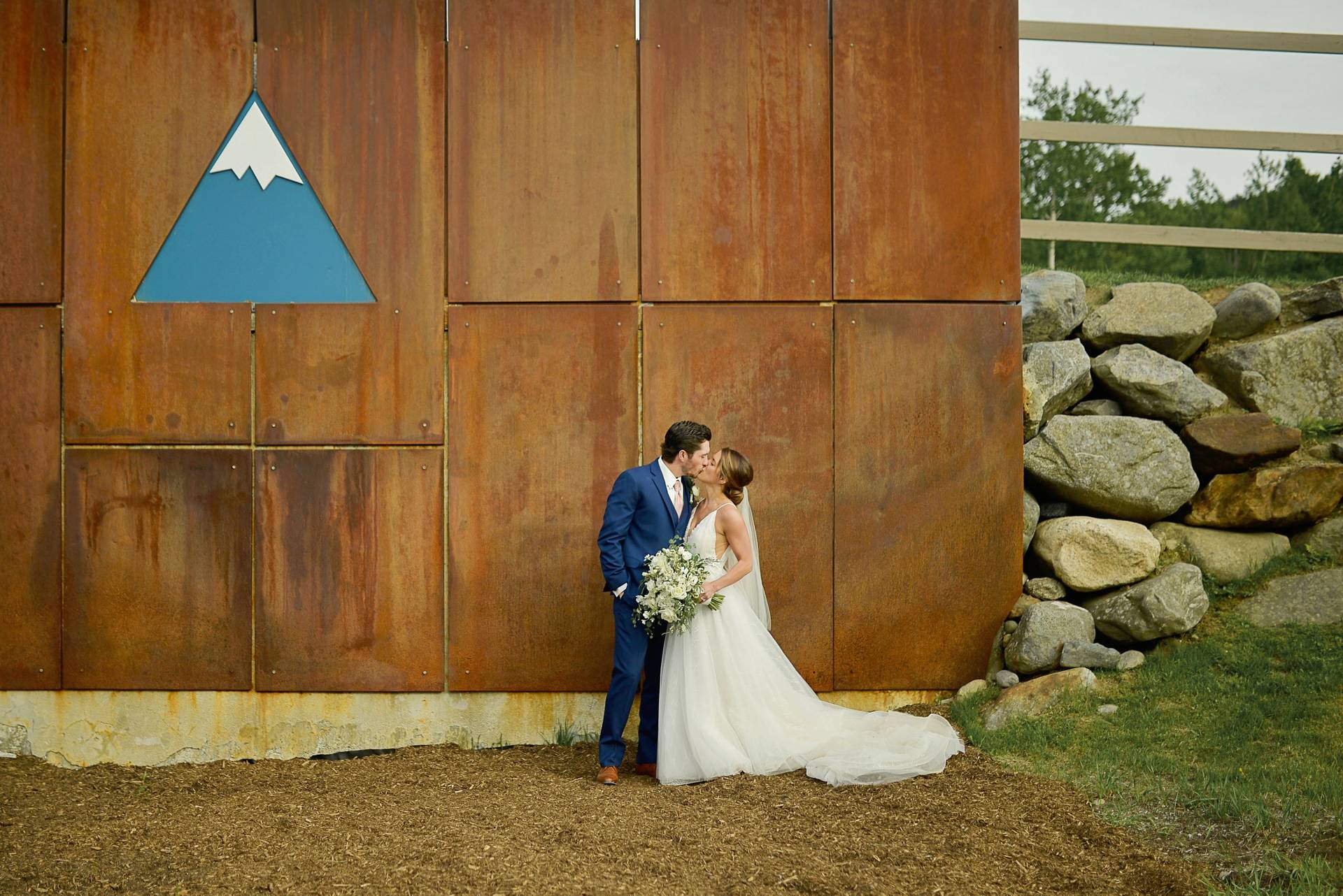 Wedding kiss in front of Sugarloaf logo