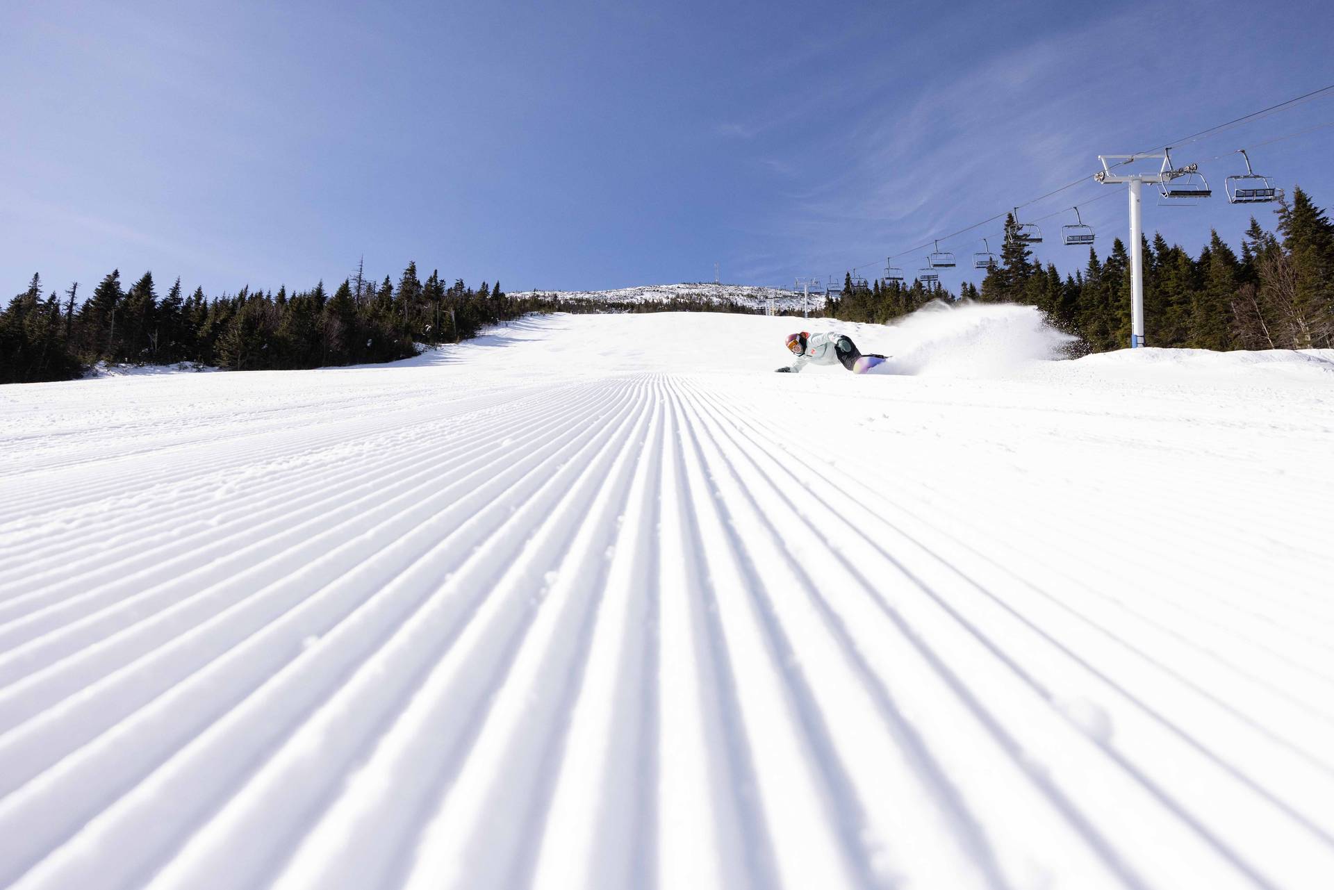 Perfect snowboarder rips down perfect corduroy
