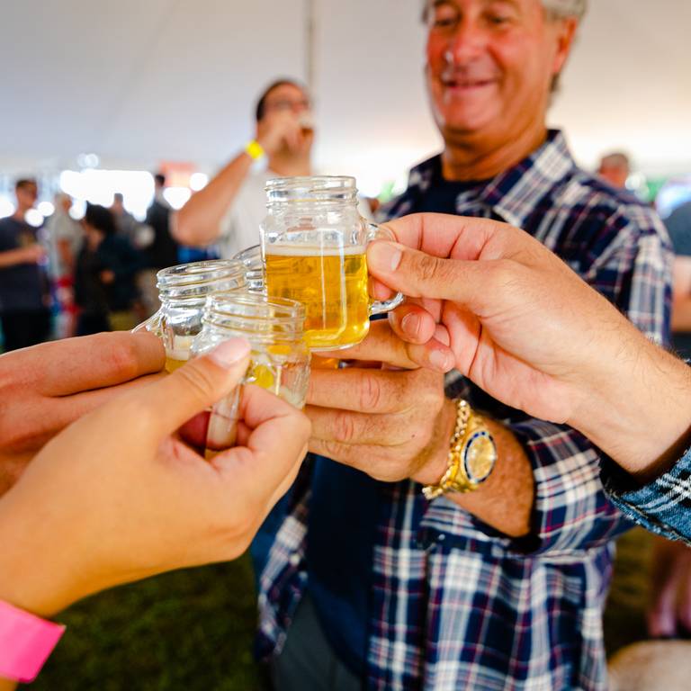 People standing under a very large tent for the Maine Brew Fest at Sunday River.