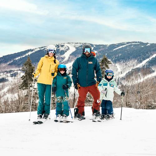 A family posing for a photo while they are out skiing at Sunday River.