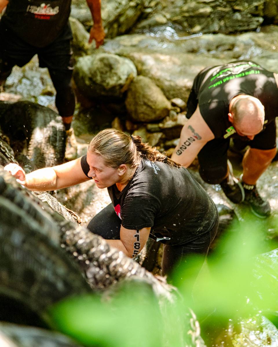 People climbing up rocks at Tough Mountain Challenge.
