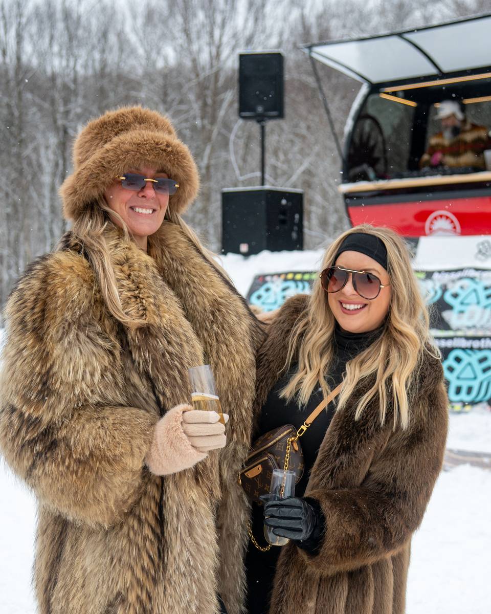 Women in fur coats at the iglu DJ stand.