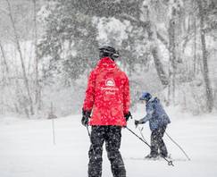 Ski school instructor coaching a lesson.