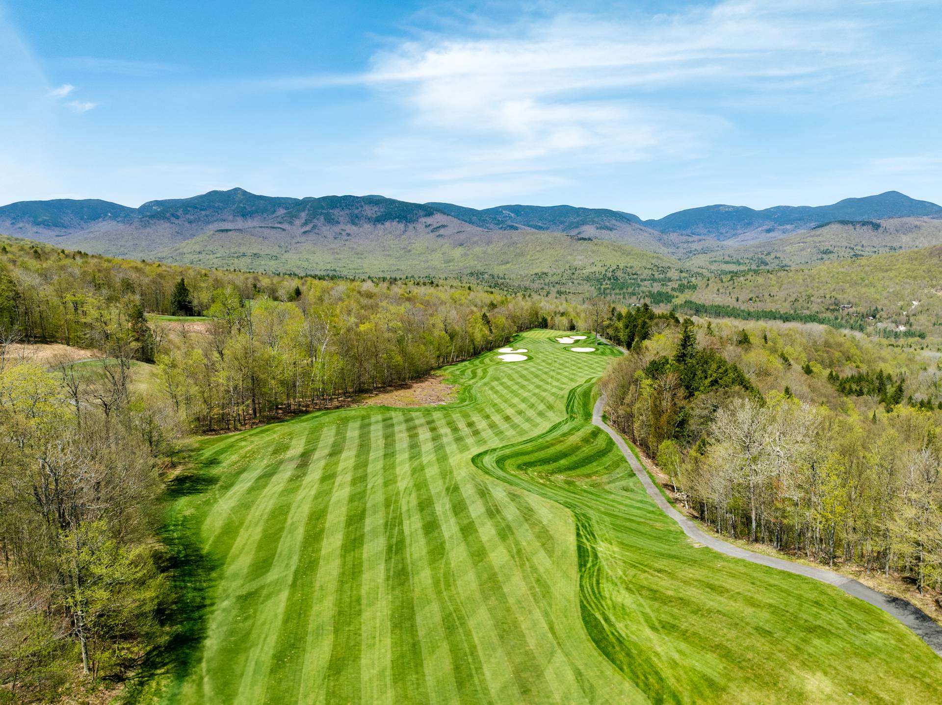 Spring at Sunday River Golf Club with a fairway and mountains.
