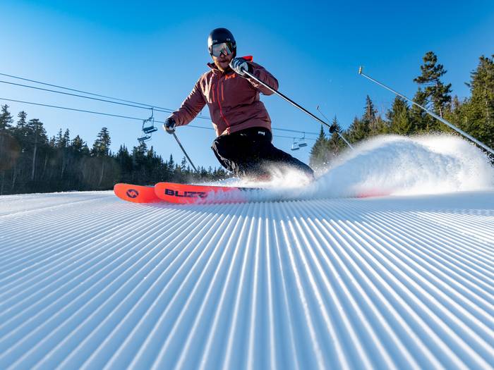 Skier skiing on perfect corduroy at Sunday River.