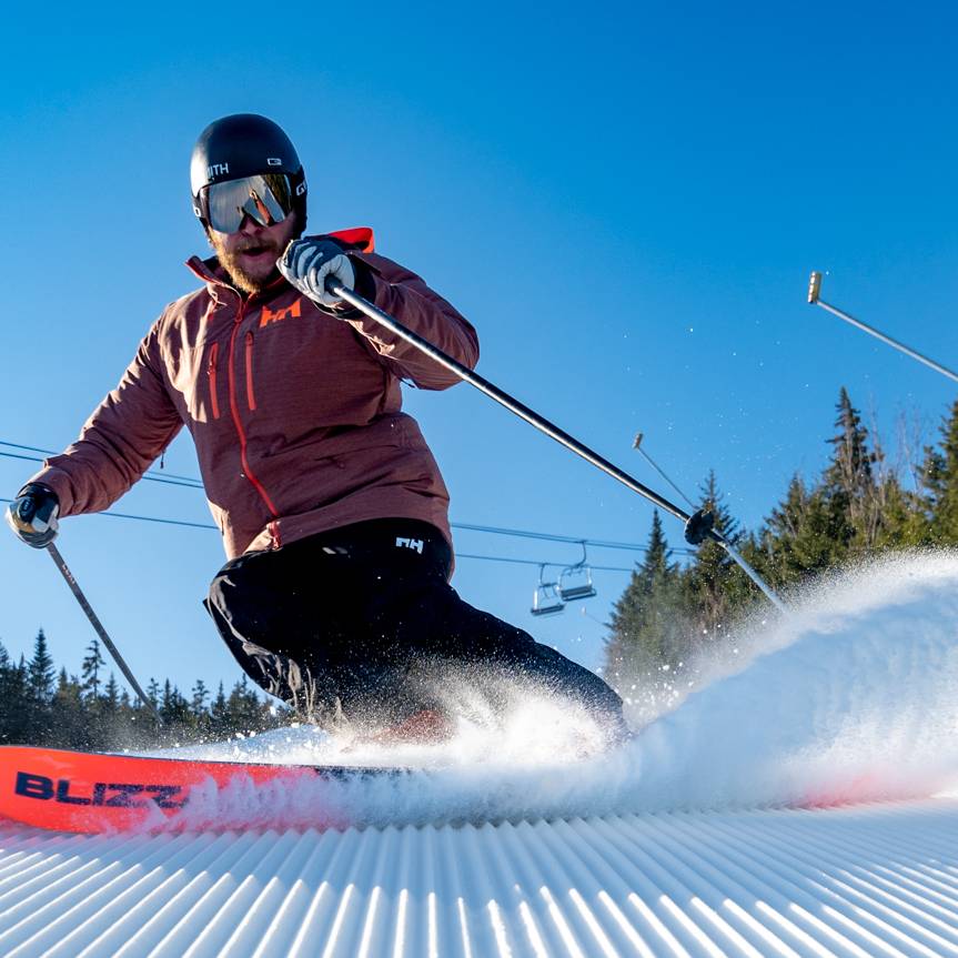 A man skiing on fresh stripes at Sunday River.
