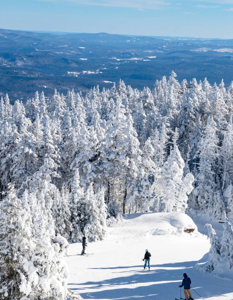 An aerial view of a snowy, tree-surrounded ski trail at Sunday River.