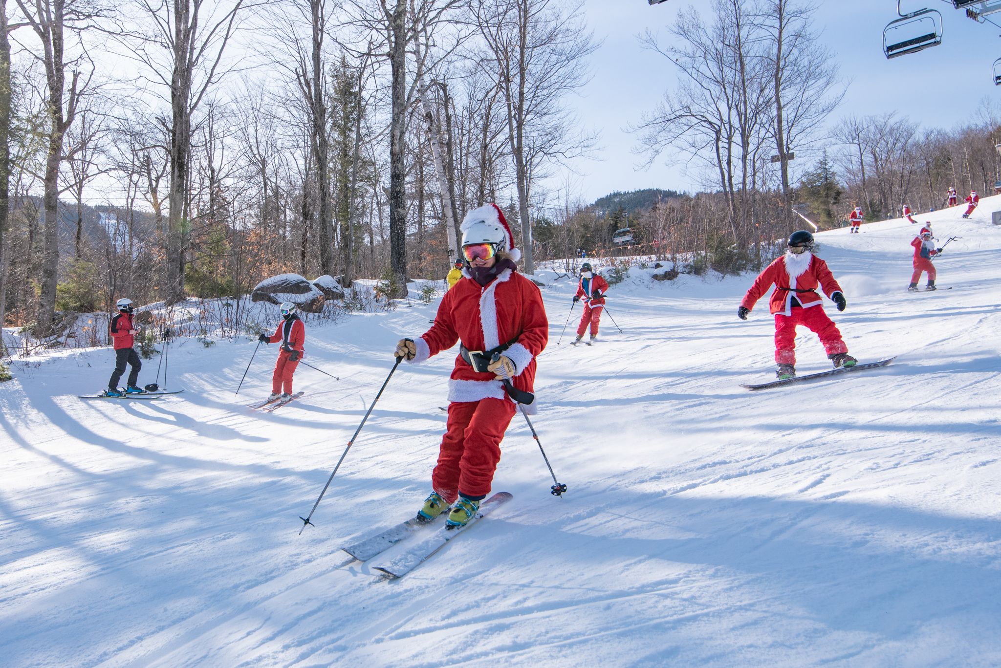 Santas skiing down a trail for Santa Sunday at Sunday River.