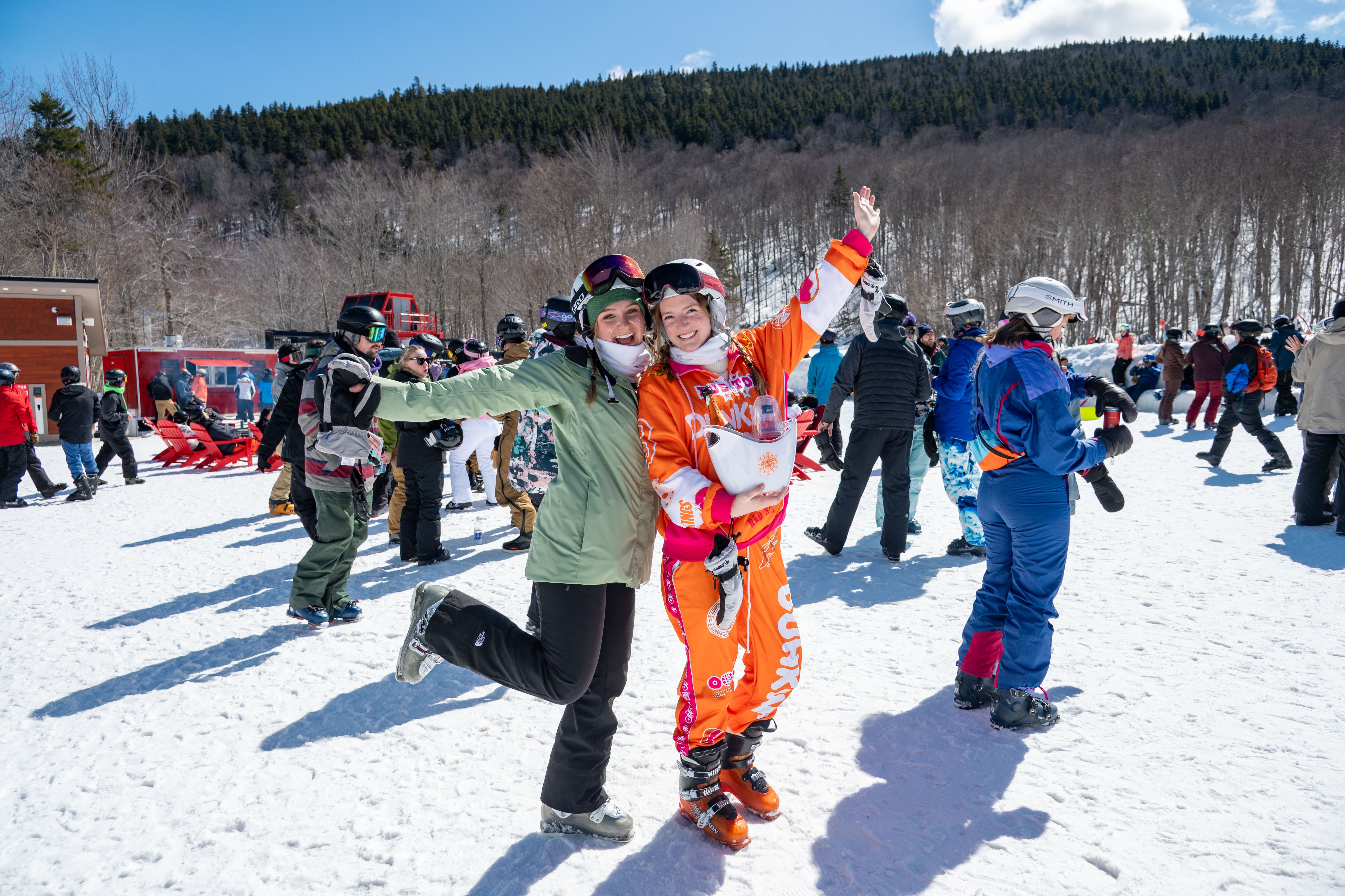 Two girls posing for a picture in ski outfits.