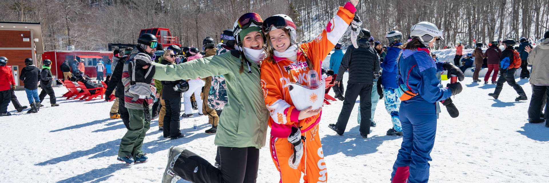 Two girls posing for a picture in ski outfits.
