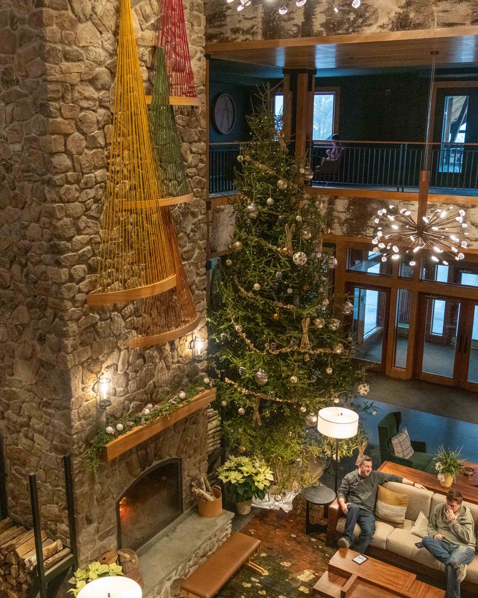 People sitting in the lobby at The Jordan with a Christmas tree in the background.