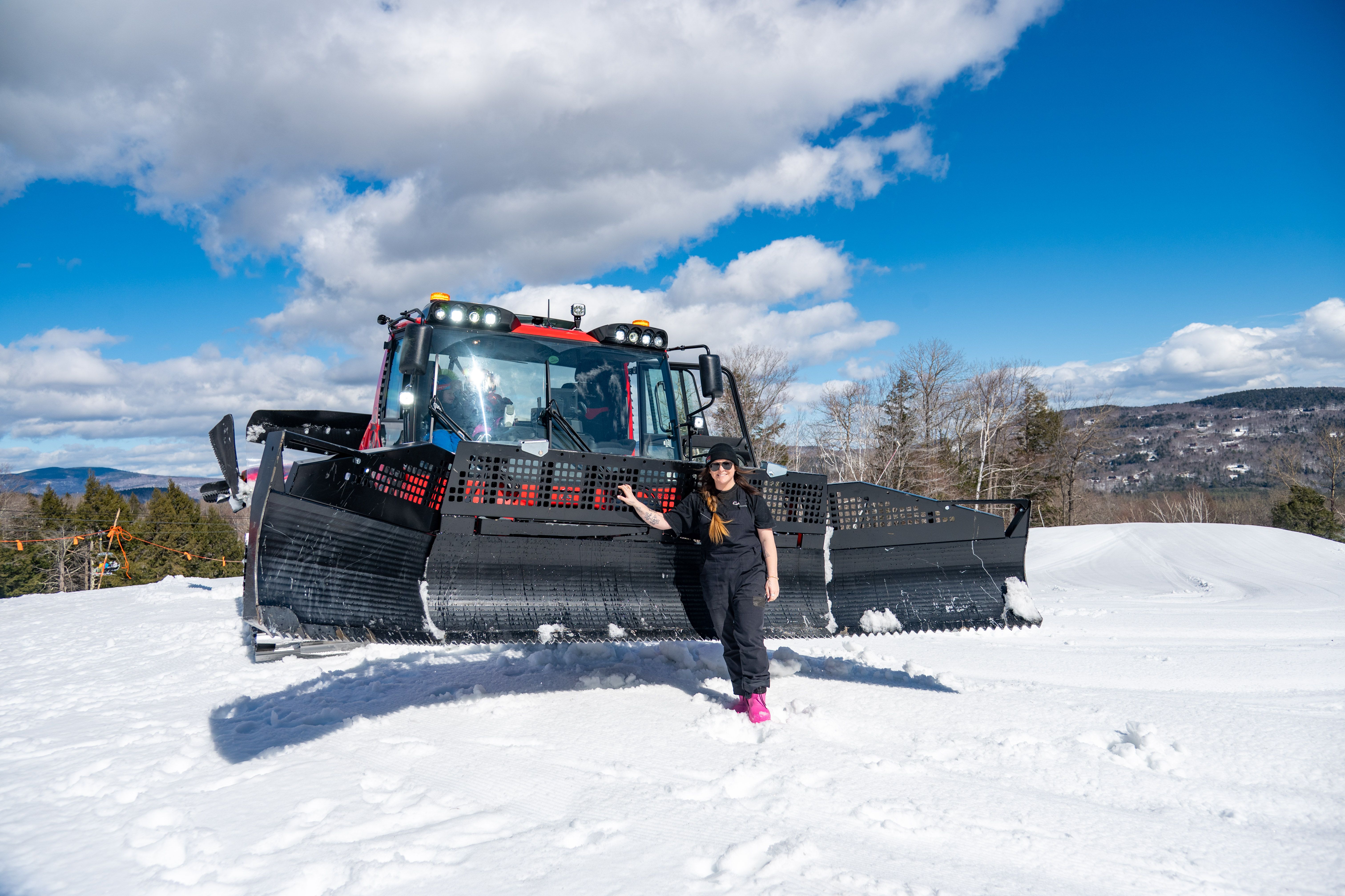 Erika Roy standing in front of a snowcat. 