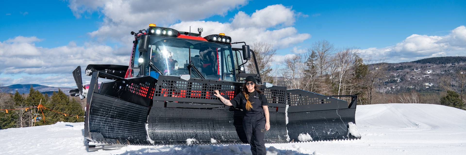 Erika Roy standing in front of a snowcat.