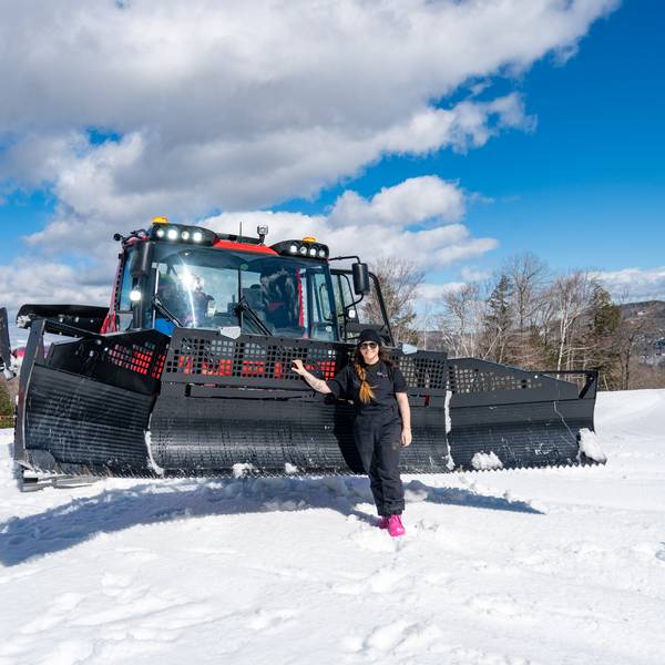 Erika Roy standing in front of a snowcat.