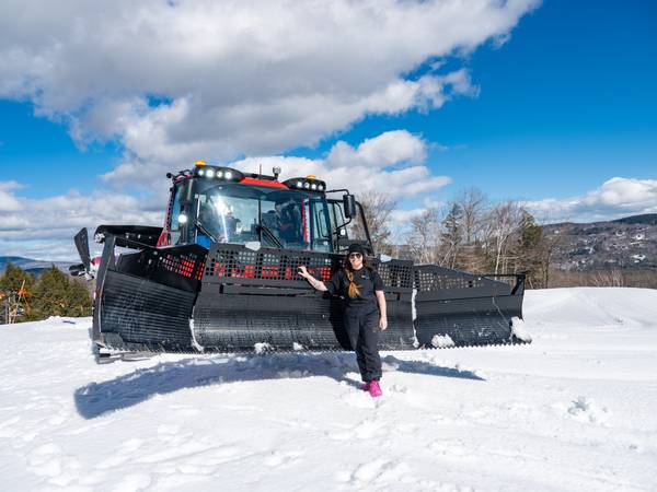 Erika Roy standing in front of a snowcat.