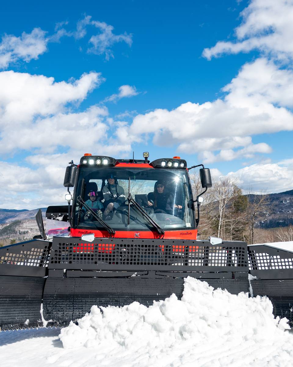 A person pushing snow during a demo at Sunday River.