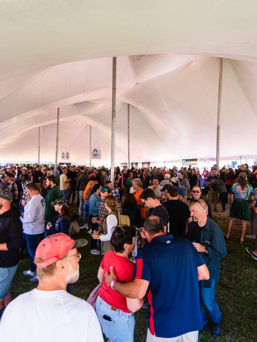 People standing and having beers under a tent at Maine Brew Fest at Sunday River.
