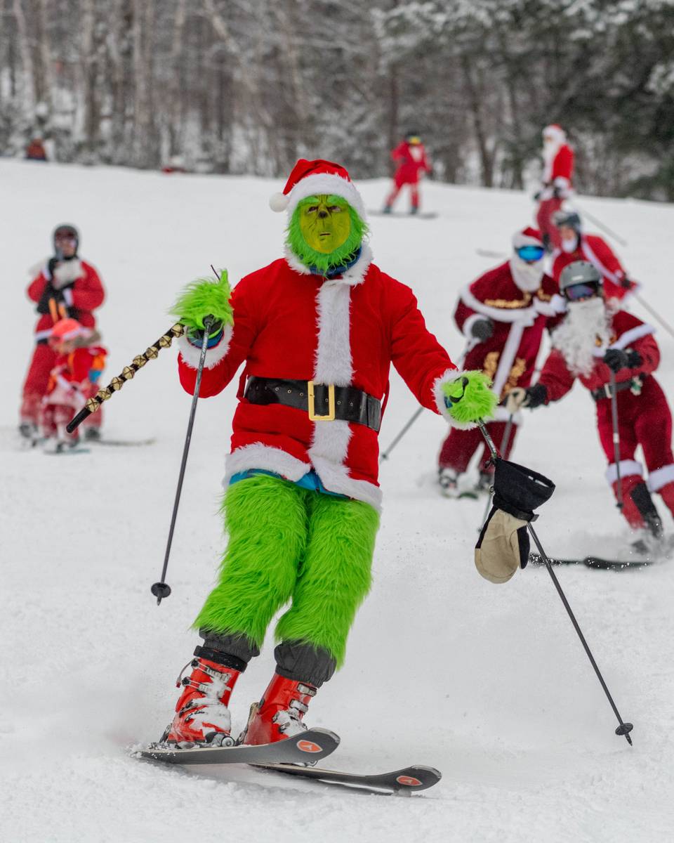 The Grinch skiing down a trail at Sunday River for Santa Sunday.