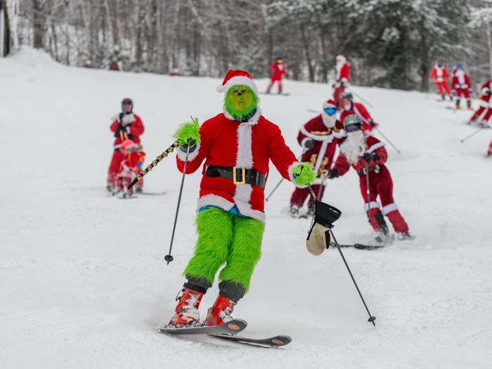 The Grinch skiing down a trail at Sunday River for Santa Sunday.