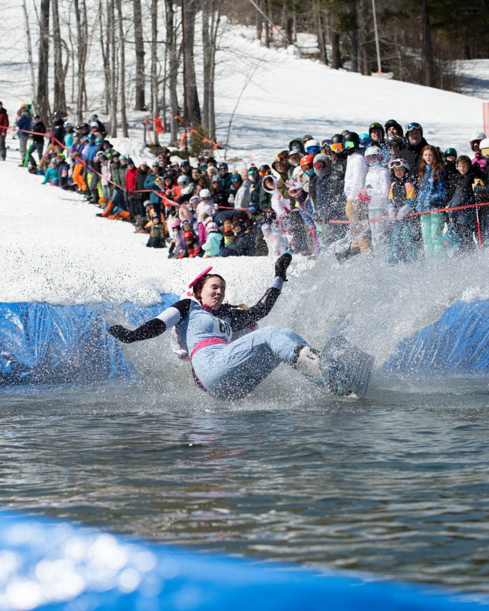 A snowboarder crashing into the pond
