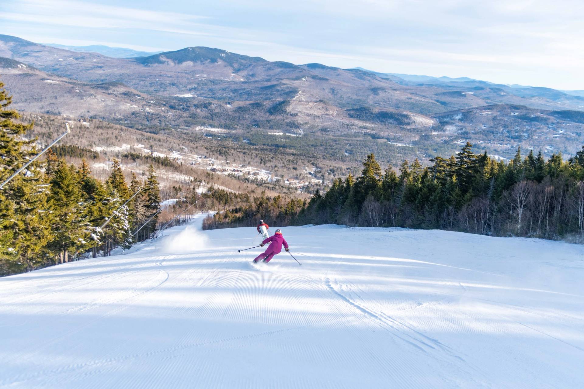 A man in a brown ski outfit skiing on fresh stripes.