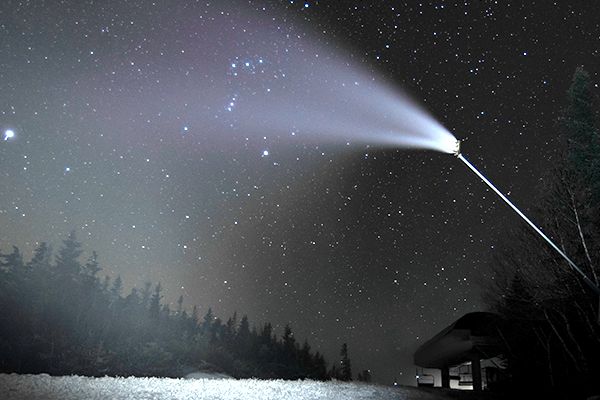 A snowgun making snow at Sunday River at night time.