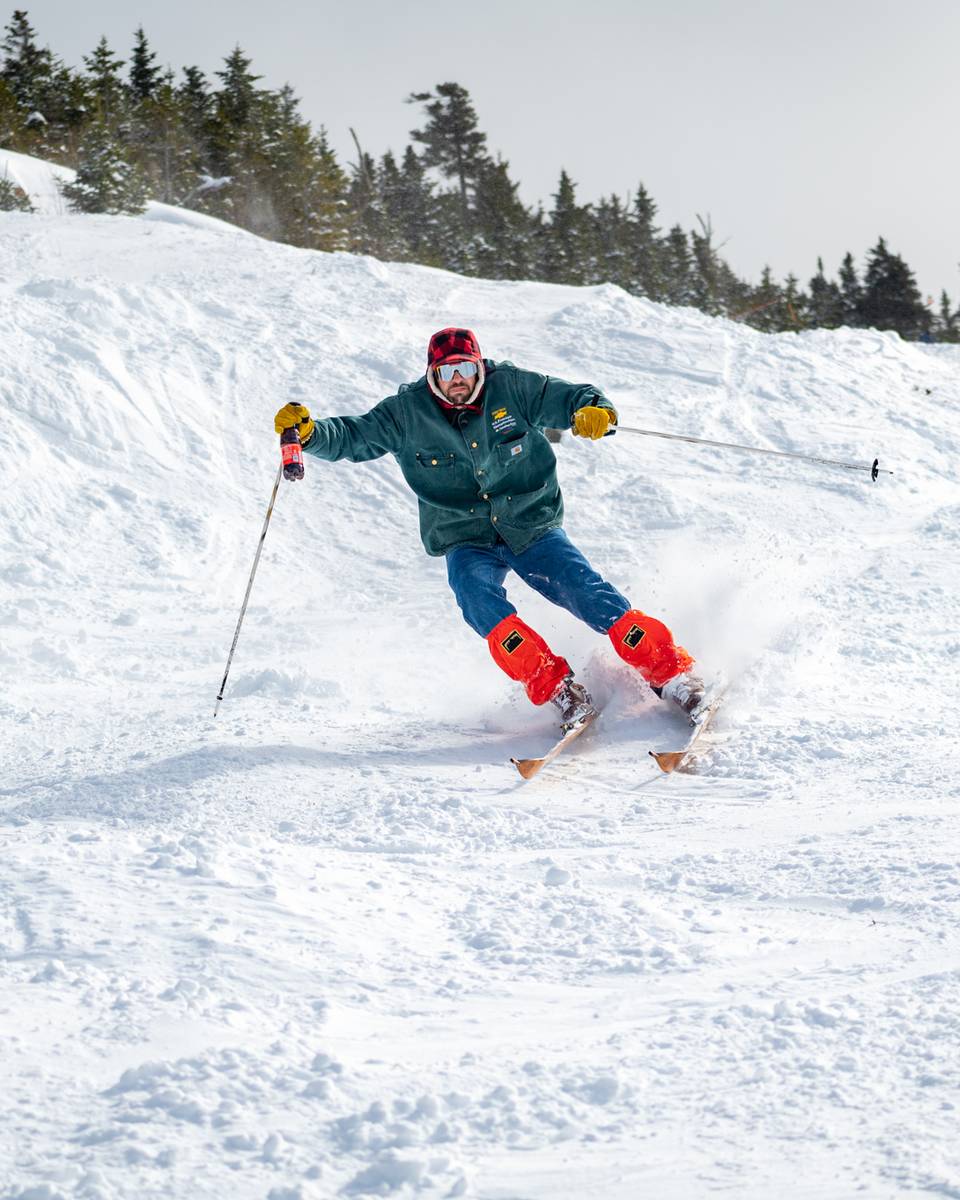 Donny Pelletier skiing with a bottle of Moxie