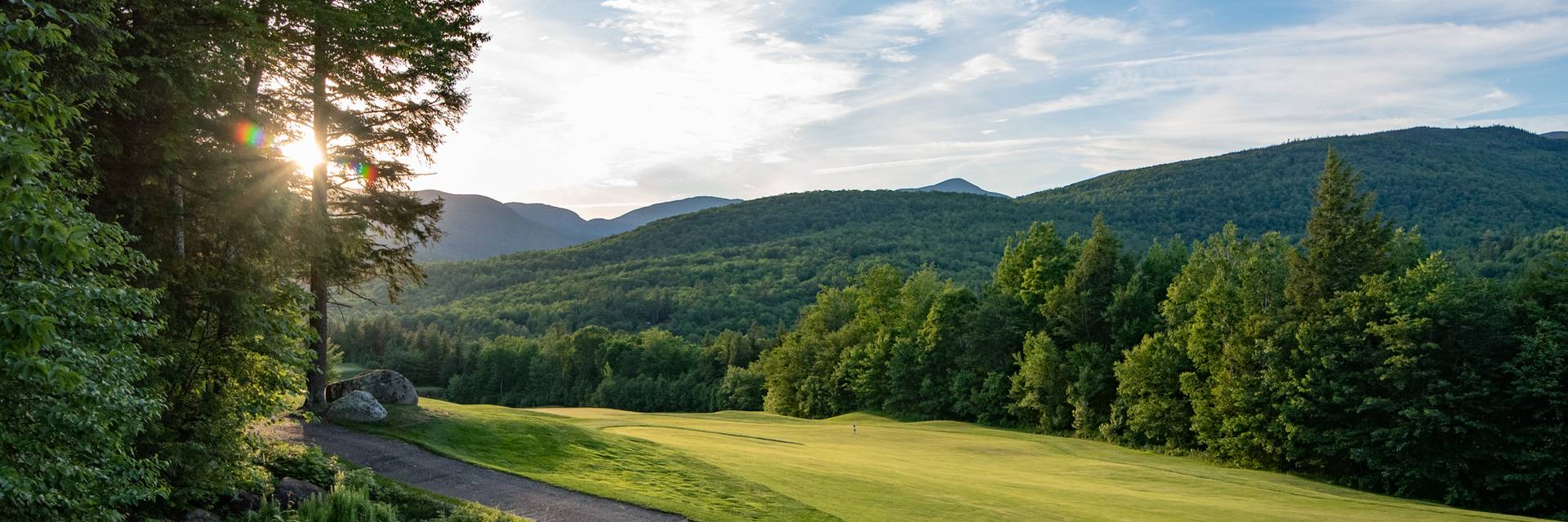 The sun setting along a green at the Sunday River Golf Club.