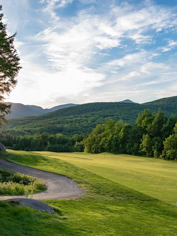 The sun setting along a green at the Sunday River Golf Club.