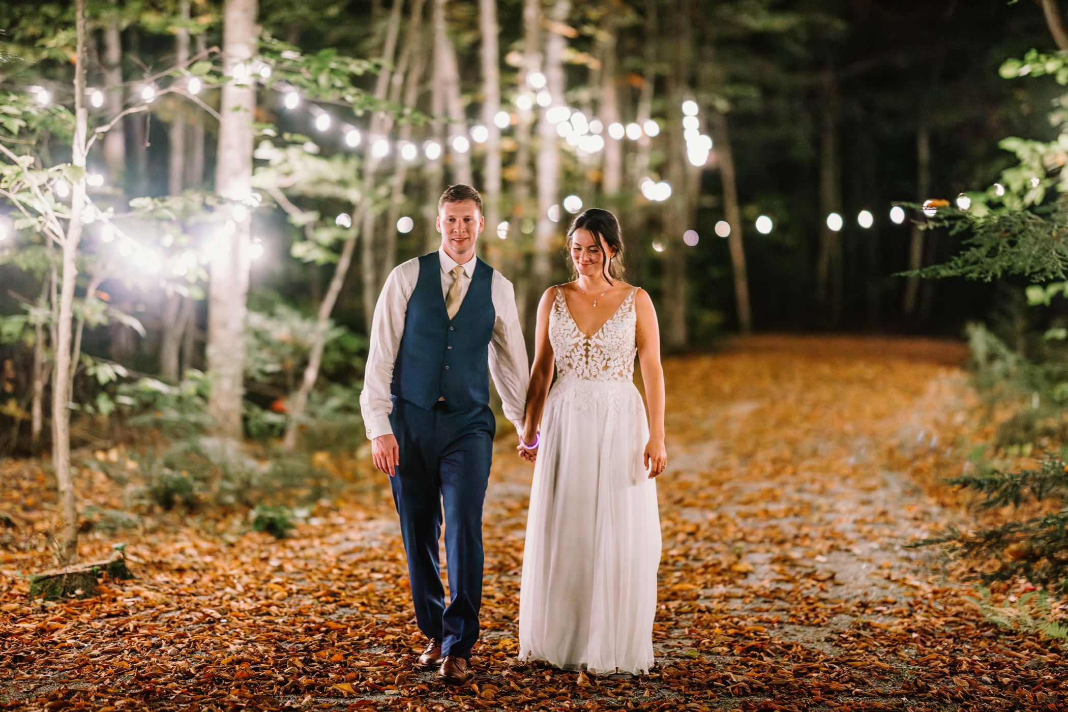 A husband and wife talking on a path with leaves at Sunday River.