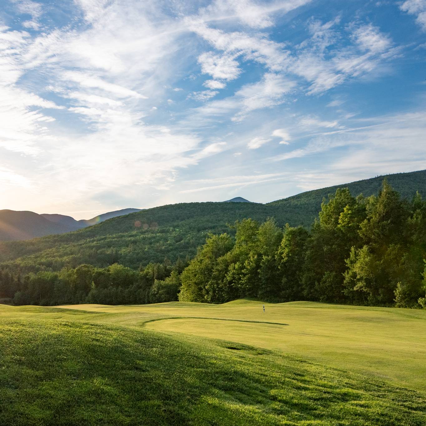 Sunday River Golf Club when the sun is setting over the course in the summer.