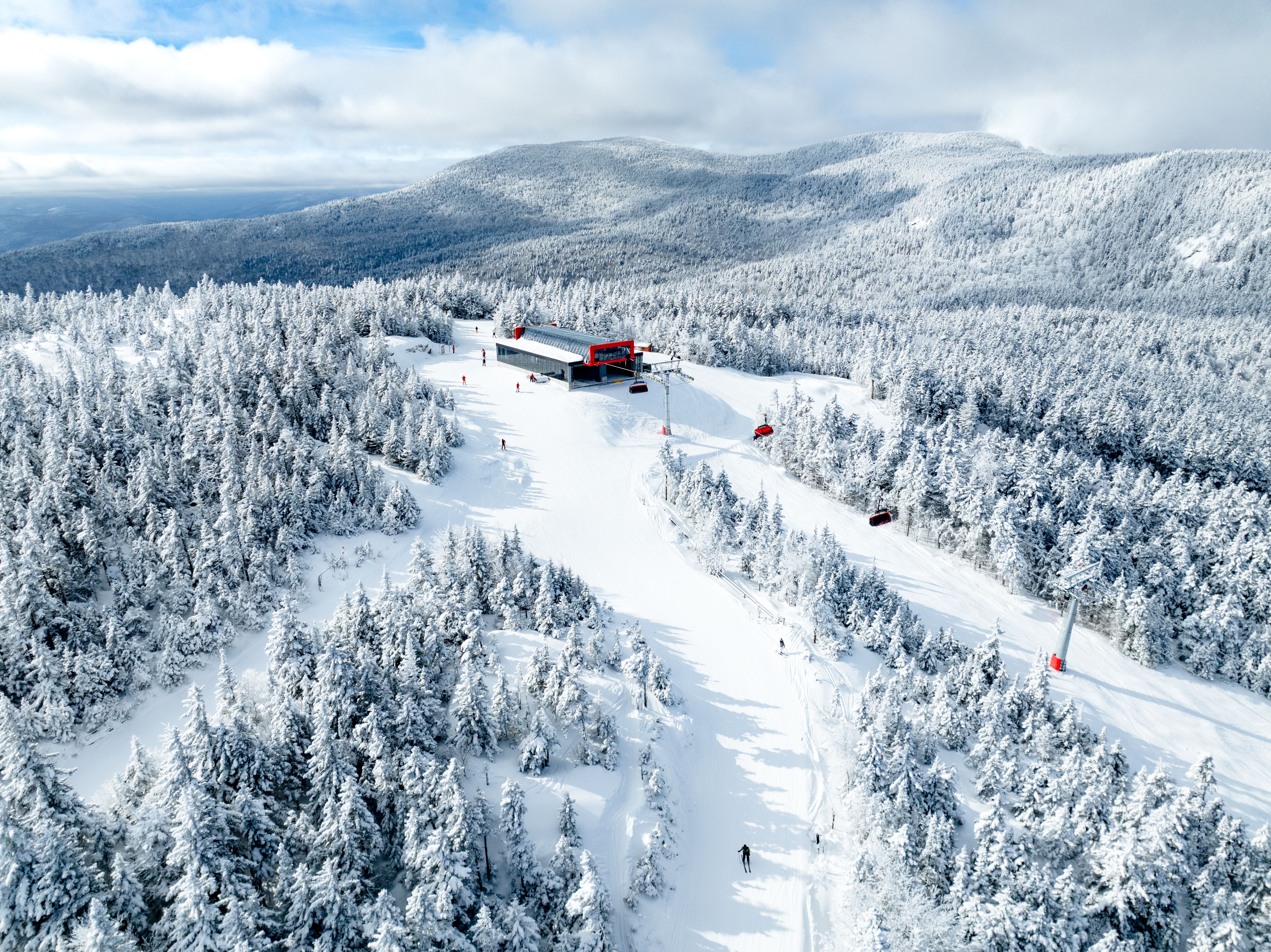 An aerial view of Barker 6 at Sunday River with skiers going down trails.
