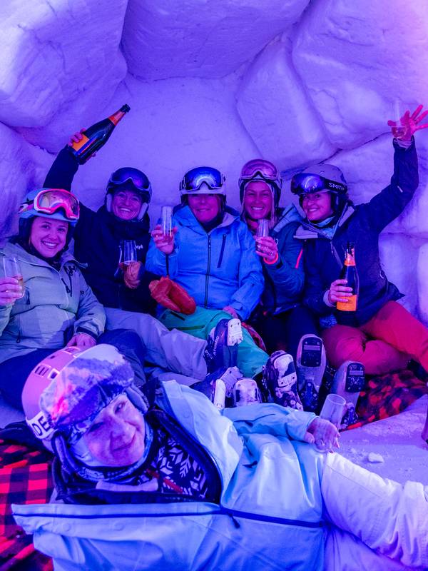 Women huddling together for a photo at The Igloo at Sunday River