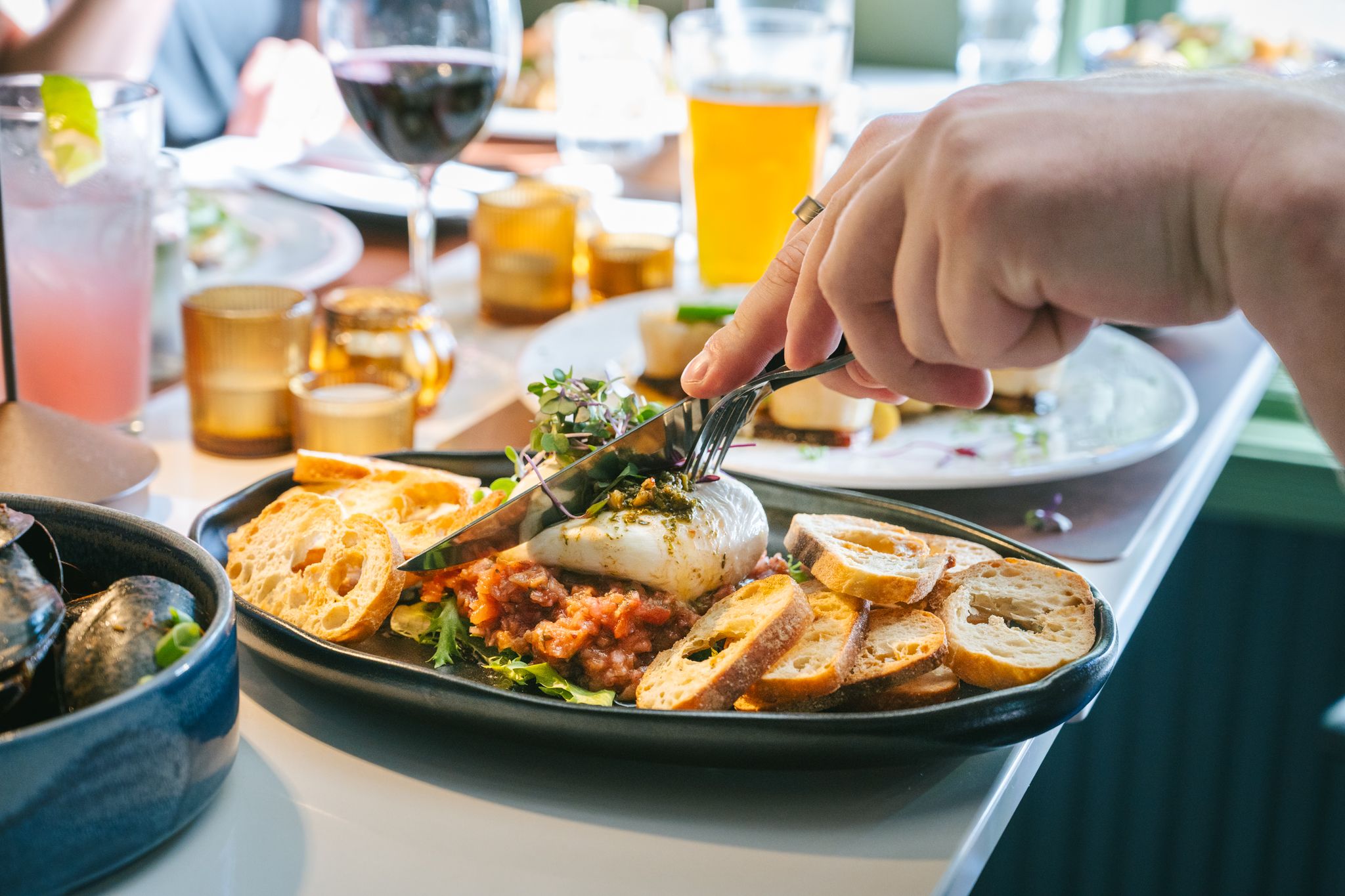 A person cutting into their dish at Ember.