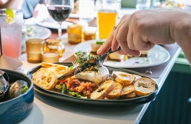 A person cutting into their dish at Ember.