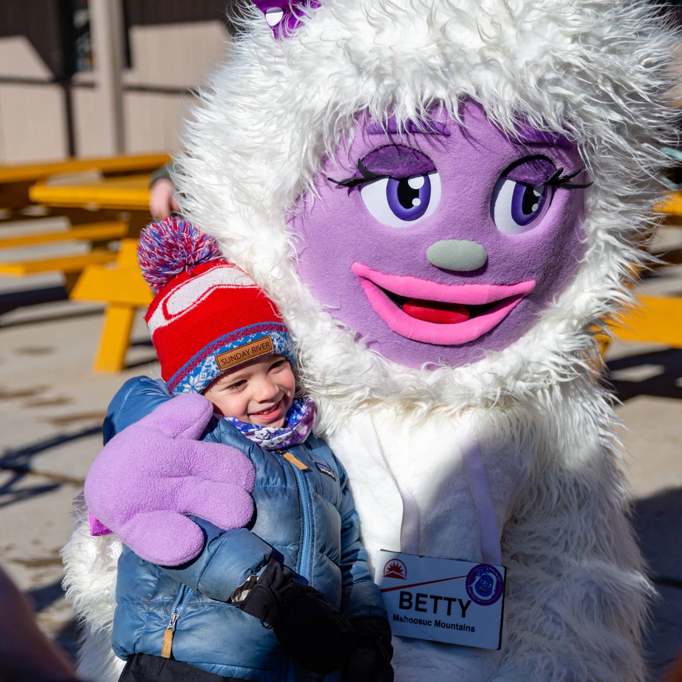 Betty the Yeti hugging a little girl at Sunday River.